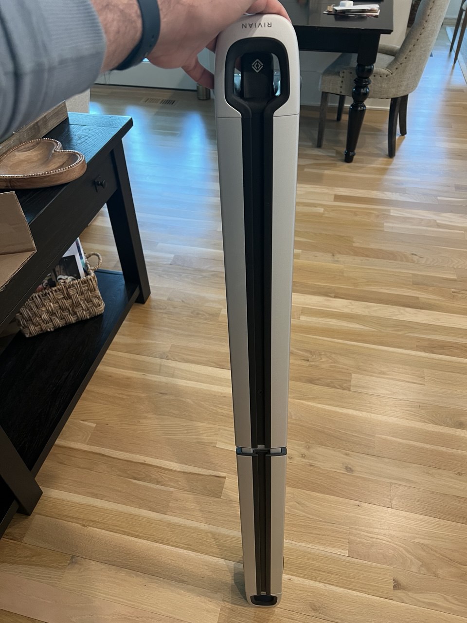 Rivian cargo crossbars installed showing two-tone silver and black design