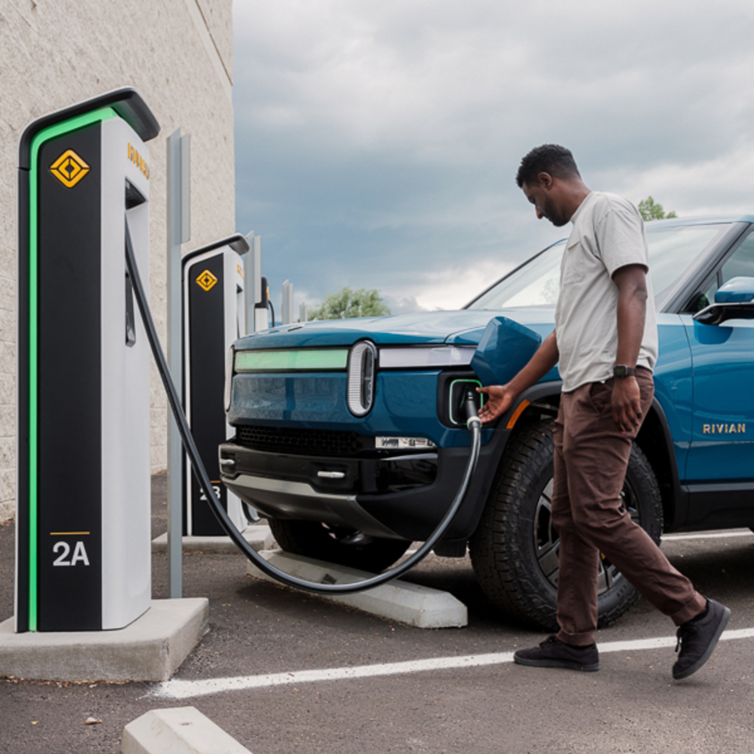 Rivian plugged into a charging station — 3 months free Adventure Network charging with referral code